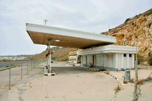 an abandoned gas station on the side of a cliff photo