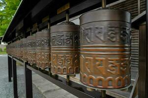 a row of prayer wheels in a buddhist temple photo