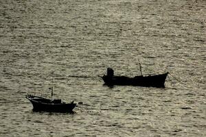 two small boats in the water near the shore photo