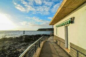 a house on the beach with a walkway leading to the ocean photo