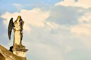 un estatua de un ángel en parte superior de un edificio foto