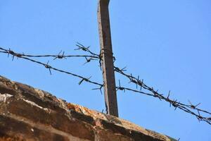 a barbed wire fence with a blue sky in the background photo