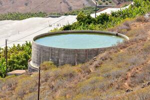 un hormigón agua tanque en un ladera foto