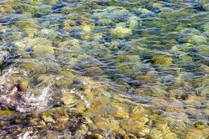 the water is clear and the rocks are green photo