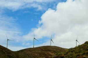 viento turbinas en un ladera con un azul cielo foto