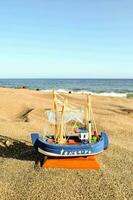 a toy boat on the beach near the ocean photo