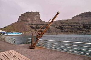 a wooden crane on the pier near the ocean photo