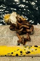 un cadena y un amarillo cuerda en el lado de un muelle foto