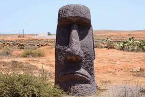 a stone statue in the middle of a desert photo