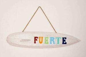 a surfboard hanging on the wall with the word fuerte photo