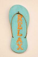 a blue wooden sandal sign with the word relax written on it photo