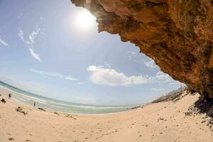 a view of the beach from inside a cave photo