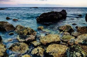 rocas y agua a puesta de sol en el apuntalar foto