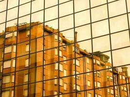 reflection of buildings in glass building in the city photo