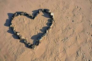 rocks on the beach arranged in a heart photo