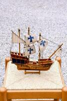 a wooden model of a ship sitting on a stool photo