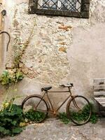 an old bike is parked against a wall photo