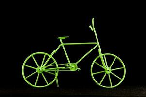 a green bicycle is shown against a black background photo