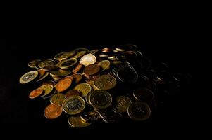 a pile of coins on a black background photo