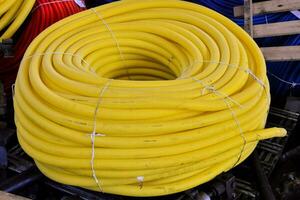 a large yellow hose is sitting on top of a pile of other hoses photo