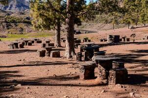 several wooden and stone benches and tables outside photo