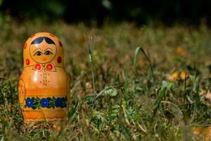 a russian doll sitting in the grass photo