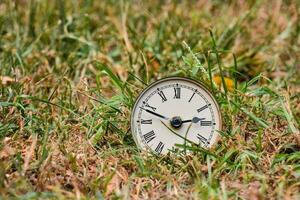 an old clock in the grass photo