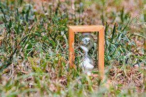 an hourglass sitting in the grass photo