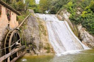 a water wheel and waterfall in the middle of a river photo