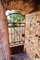 an old gate in a brick wall with a door photo