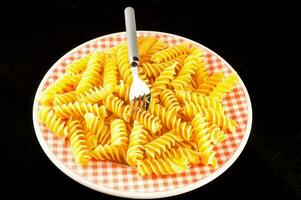 A plate with pasta isolated on black background photo