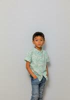 Cute little boy in casual outfit on background photo