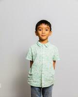 Cute little boy in casual outfit on background photo