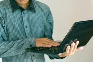 Male hand using laptop computer to work, business concept photo