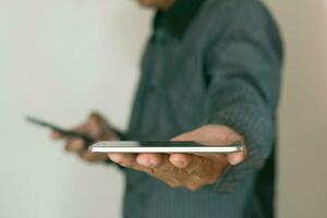 Close-up shot of a man's hand using two smartphones and holding out a mobile phone. business idea photo