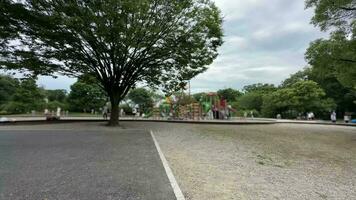 un parque con un patio de recreo y arboles video