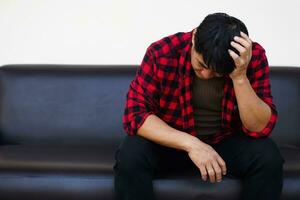 Asian man feels sad, stressed, depressed, hand covered his head. Concept, drepression, failure, disappointment, broken heart. guilty, have life problems. Major Depressive Disorder photo