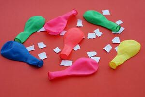 Colorful balloons and small pieces of paper on pink background. Concept, equipment for doing science experiment about static electricity. Easy and fun science project work activity for kids. Education photo