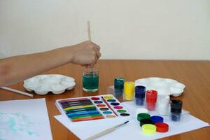 de cerca estudiante es estudiando Arte sujeto, cuadro, Arte actividad, disfrutar y concentrado en favorito actividad con muchos colores. concepto, educación. aprendizaje por haciendo, mejorar niño imaginación. foto