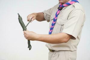 Keeping long rope to be shorter,  demonstrated by scout teacher trainer. Concept, useful tying knot for many purposes in daily life. Tying knot rope teaching aid. Life skills with rope. photo