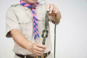 Tying rope knot pattern, demonstrated by scout teacher trainer. Concept, useful tying knot for many purposes in daily life. Tying knot rope teaching aid. Life skills with rope. photo