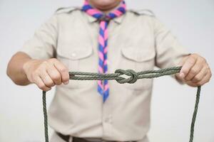 Tying rope knot pattern, demonstrated by scout teacher trainer. Concept, useful tying knot for many purposes in daily life. Tying knot rope teaching aid. Life skills with rope. photo