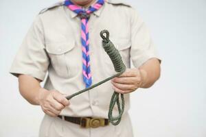 Keeping long rope to be shorter,  demonstrated by scout teacher trainer. Concept, useful tying knot for many purposes in daily life. Tying knot rope teaching aid. Life skills with rope. photo