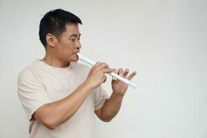 Asian man is playing flute, musical instrument. Concept, love music. Melody therapy, make concentration. Man practices to play music for being professional flutist. photo