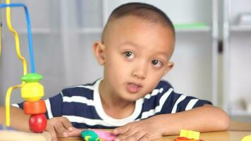 Boy making plasticine to promote development on the table in the house. video