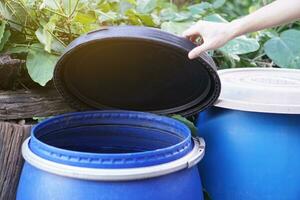 Closeup hand hold lid to cover water jar to protect from mosquito to breed inside or other  insects or dust go into water. Concept, campaign to stop mosquitoes cycle to lay eggs in water container photo