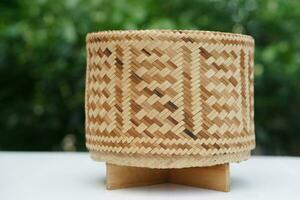 Woven bamboo rice box in cylinder shape for contain sticky rice. Concept , handmade, handicraft. Thai wisdom to use natural materials to be kitchenwares. Safety food with nature  container. photo