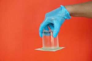 Closeup hand hold and turn  a glass of water over down. covered the glass with paper. Concept,  science experiment about air and liquid pressure. Easy science subject activity, education. photo