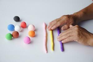 Close up hands sculpt plasticine into different shapes. Concept, alzheimer. weak muscle patients recovering activity by sculpting. Make concentration for ADHD or autistic symptom kids. Enhance imagine photo