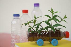 DIY car which grow plants, made from plastic bottle and caps.  Concept, Seedling from recycle crafts. Reduce, reuse and recycle plastic garbage photo